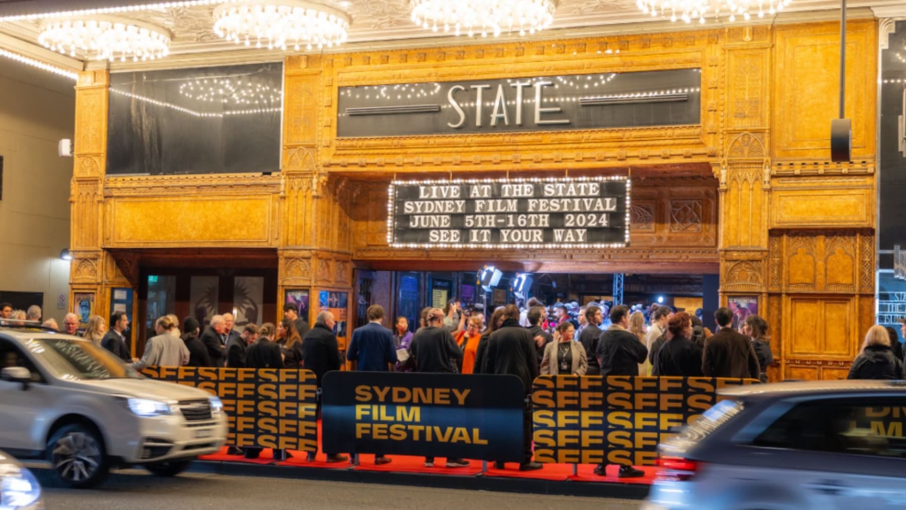 People queuing outside State Theatre in Sydney. The sign reads "Live at the State Sydney Film Festival June 5th - 16th 2024 see it your way"