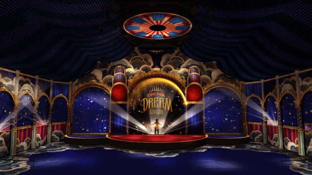 A stage, illuminated by spotlights, is situated within an ornate, circus-themed venue