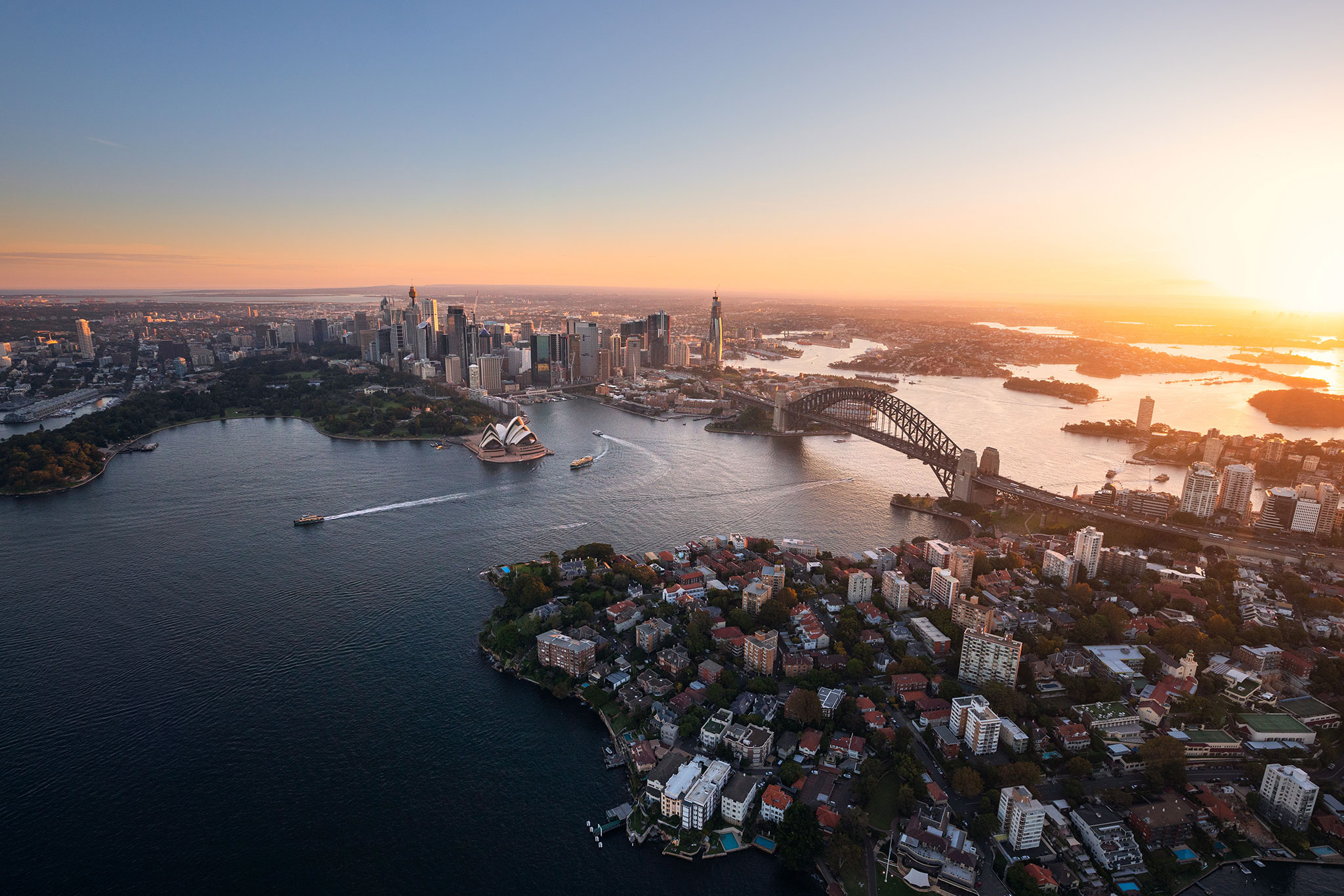 A city skyline is viewed from above at sunset