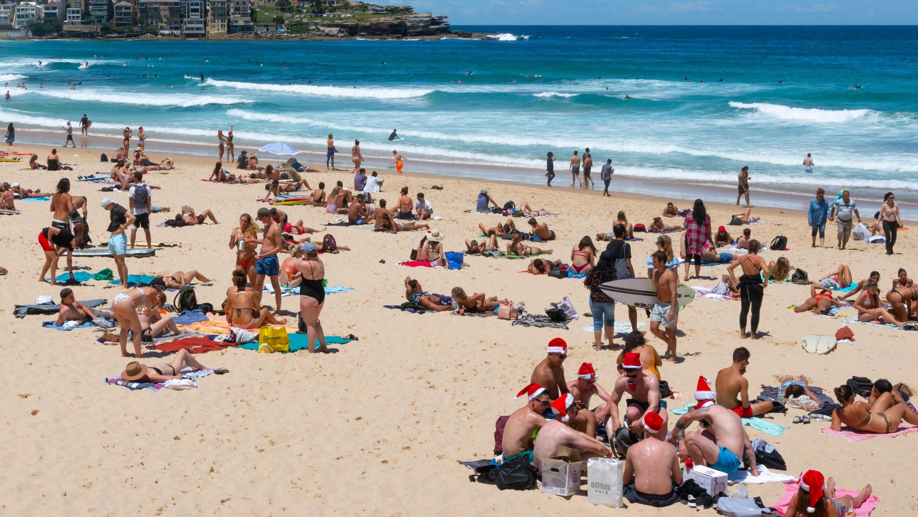 people wear santa hats on Bondi Beach during Christmas in Sydney