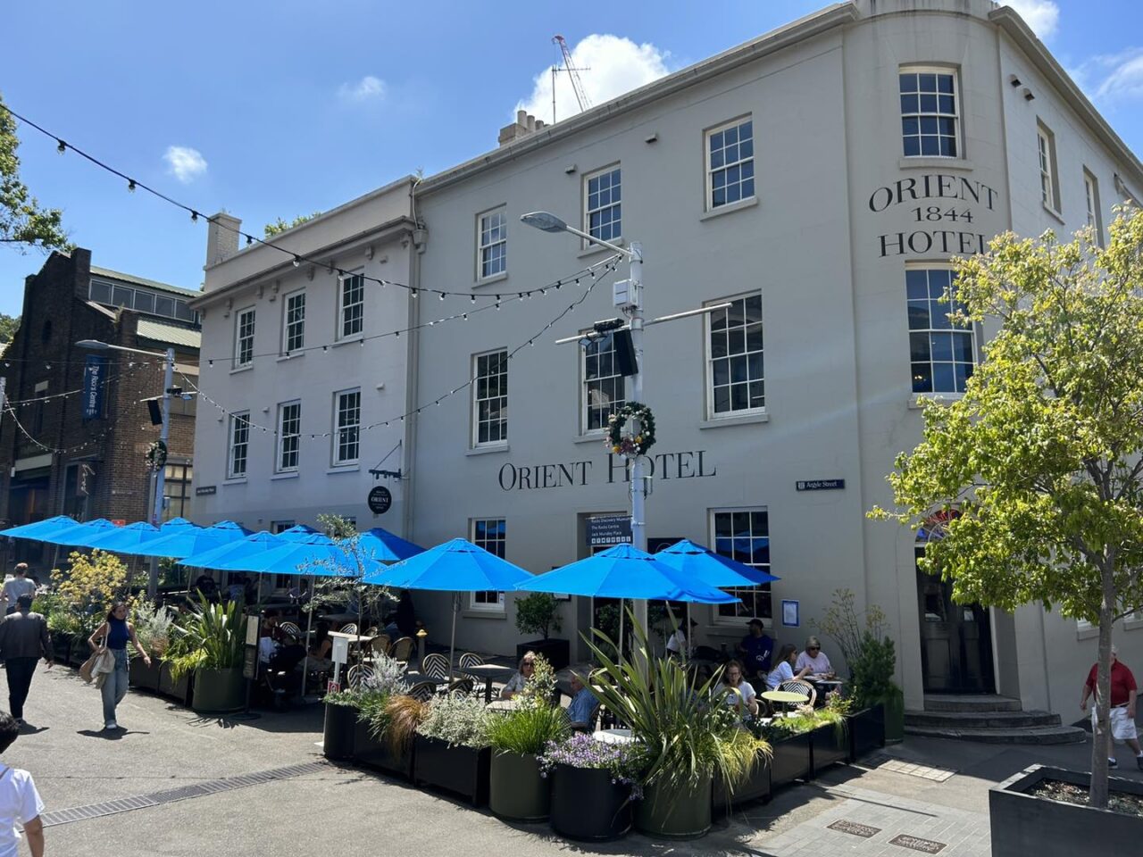 A three-story Orient Hotel, established in 1844, sits on a sunny street