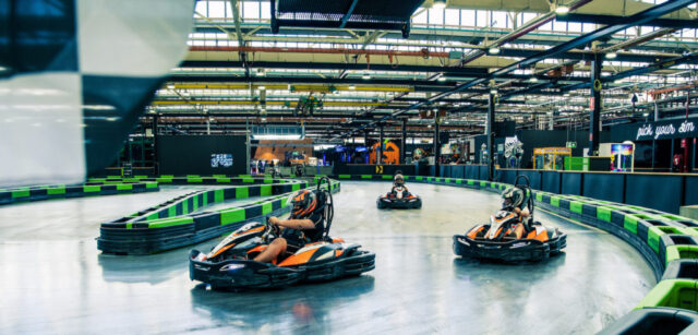 Go-karts are racing on an indoor track