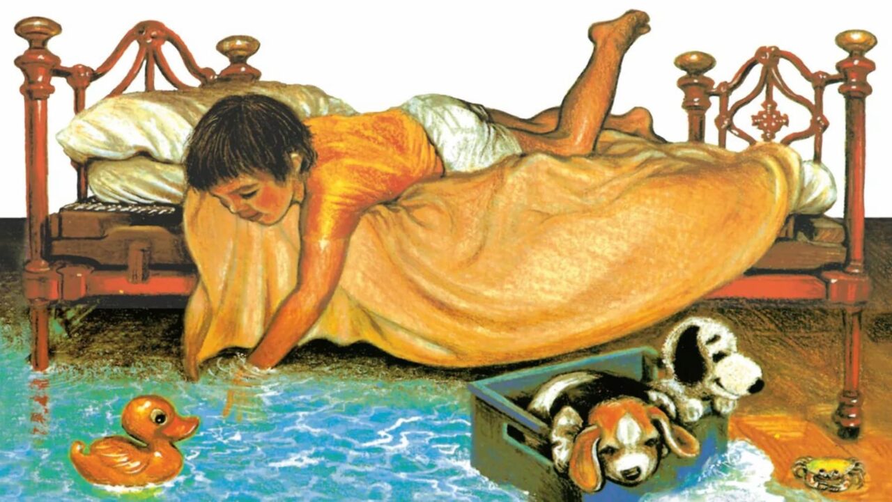 A boy reaches into floodwaters from his bed
