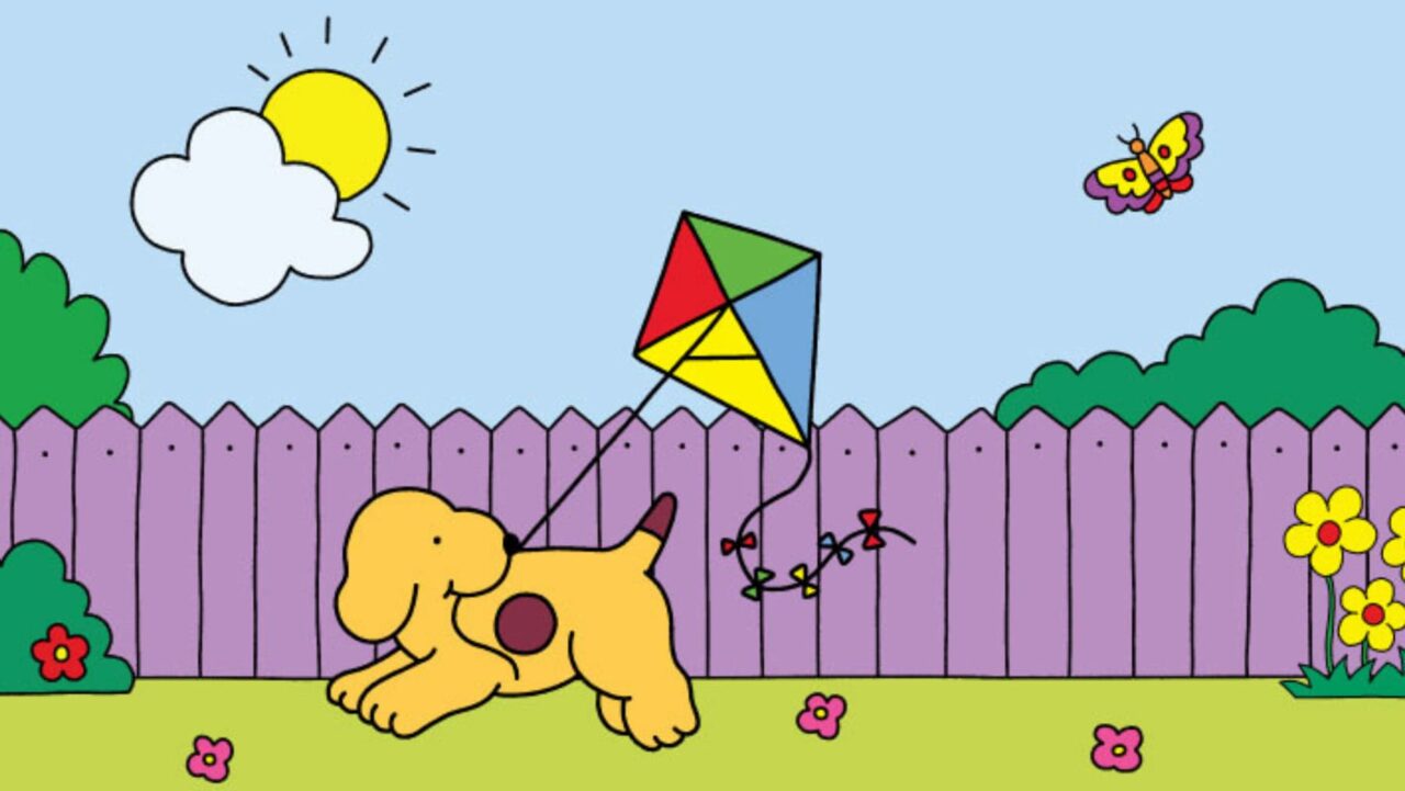 A yellow puppy holds a colorful kite's string while running in a garden enclosed by a purple fence