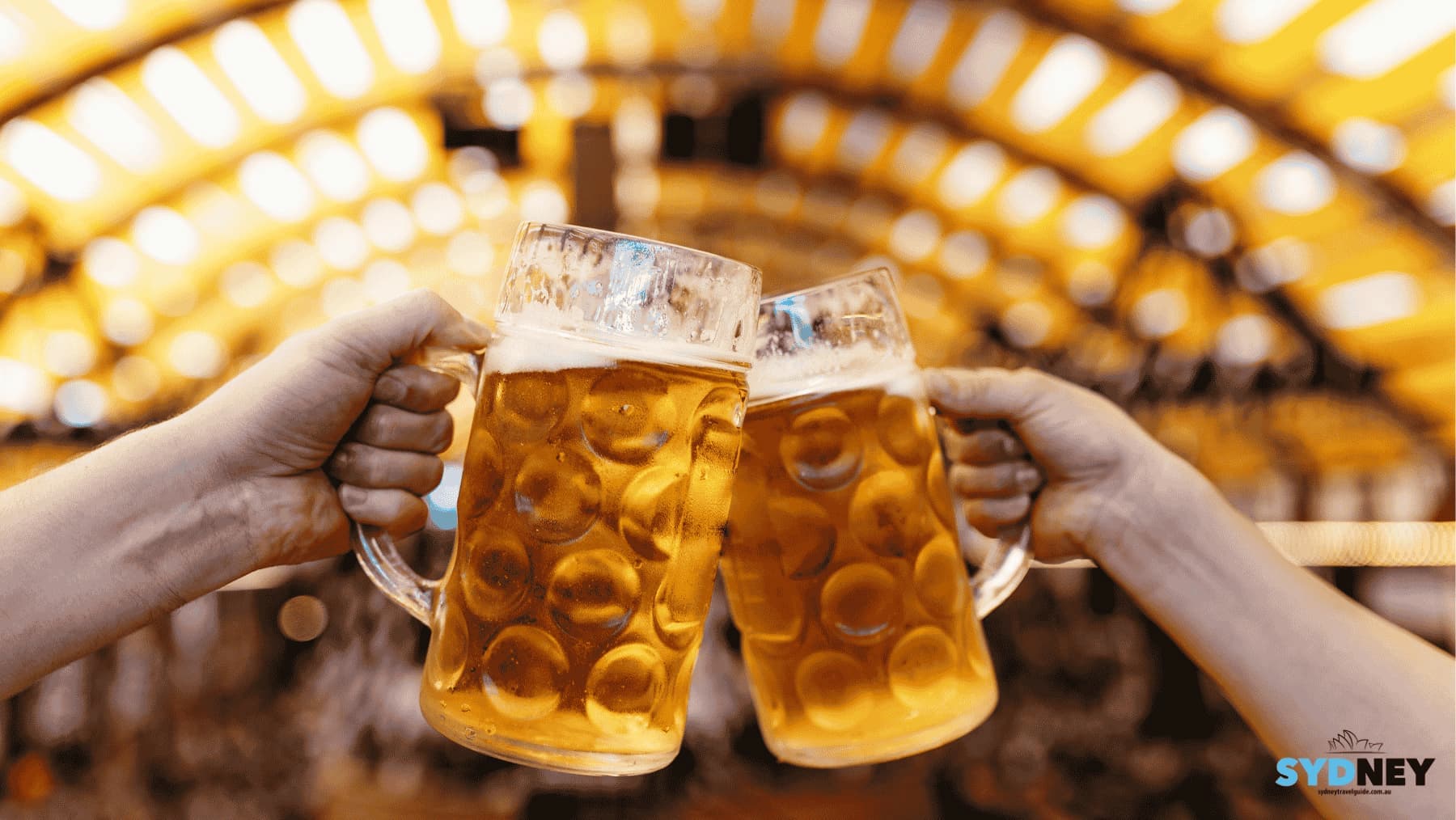 Two beer steins clink together in a celebratory toast, under a golden, blurred-out festive tent