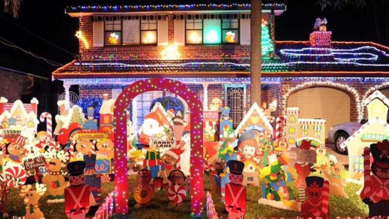 A brick house is decorated with numerous Christmas displays