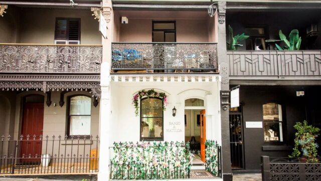 A white storefront, adorned with artificial flowers
