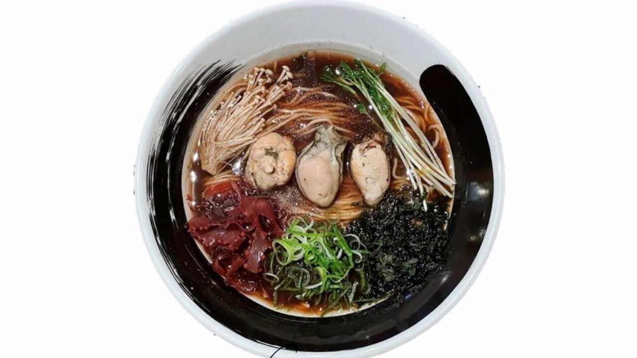 A bowl of ramen sits on a white background