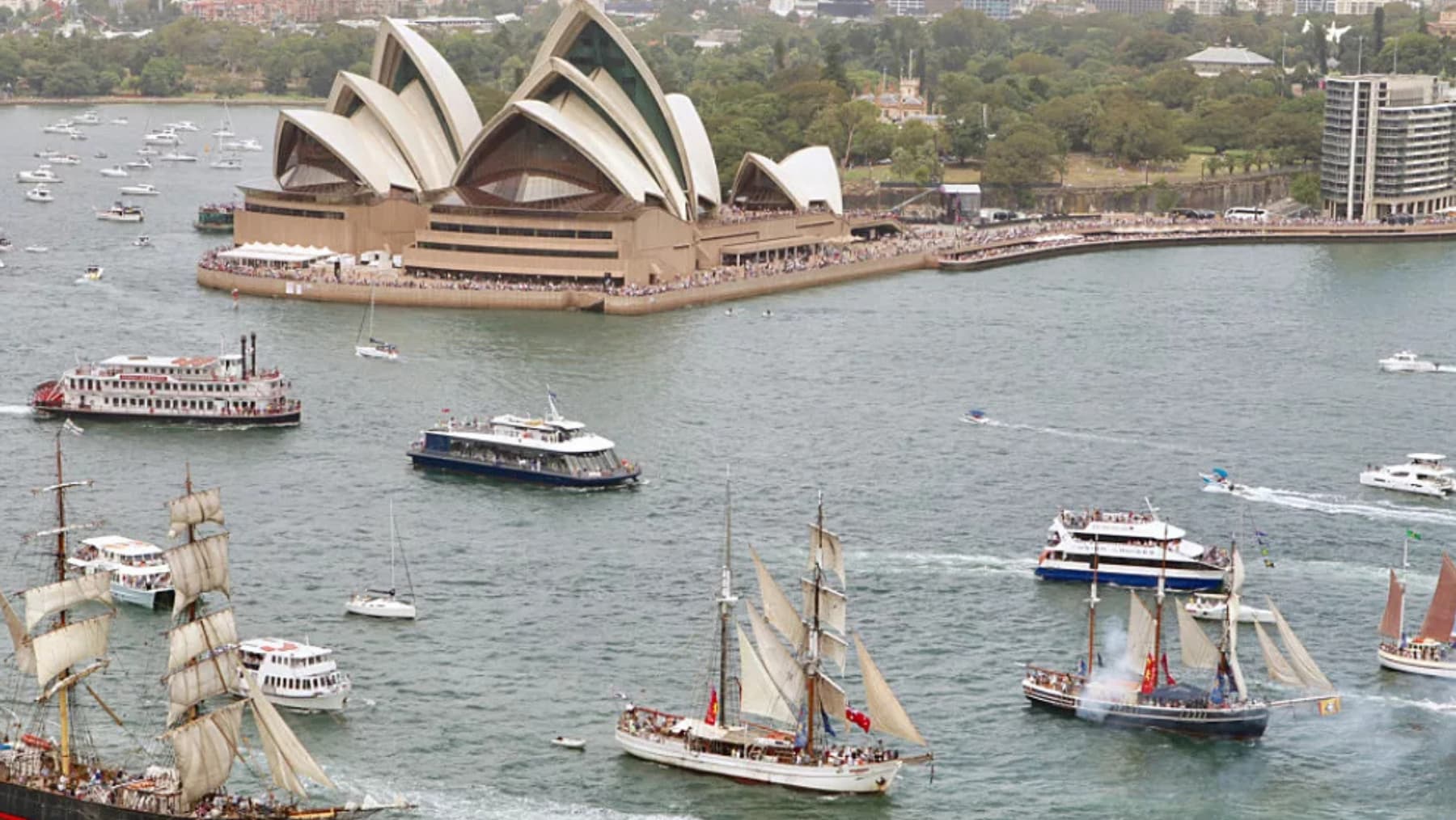 Many different ships on Sydney Harbour with the Sydney Opera House in view.