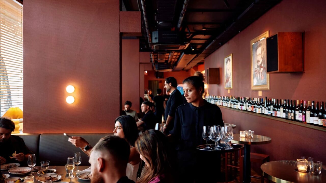 a group of people sitting at tables in a restaurant
