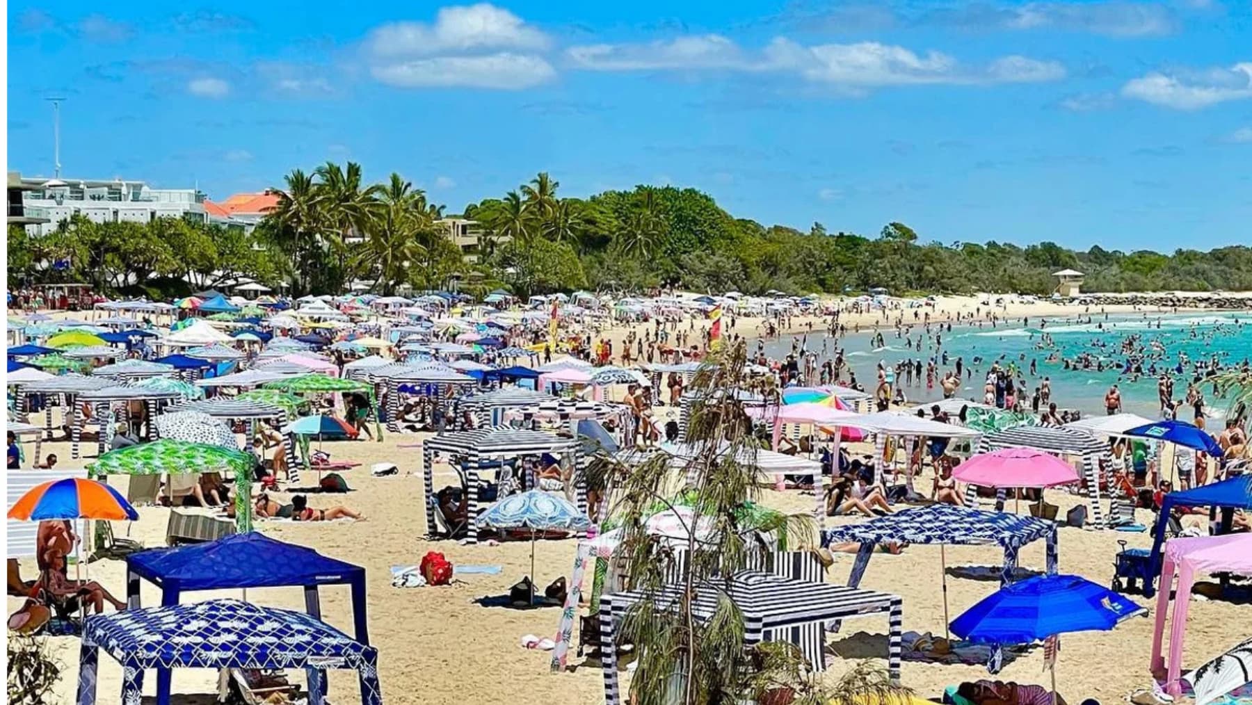 Beach cabanas crowd an Australian beach