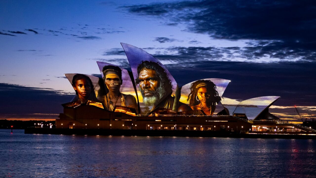 Sydney Opera House sails illuminated with the face of Aboriginal people.