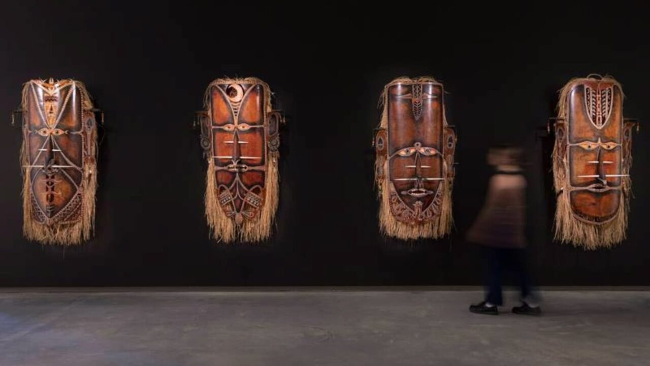 a person walking past a wall with a pair of masks