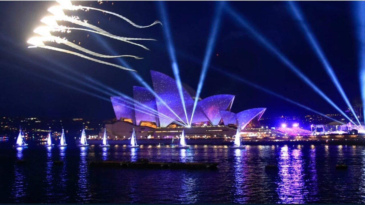 The Sydney Opera House with lasers in the sky.