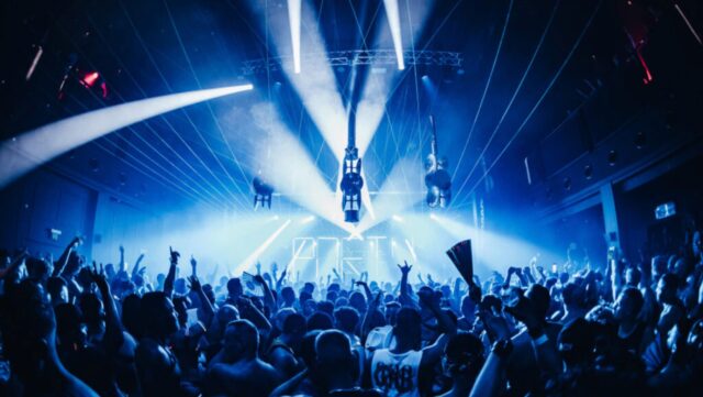 Club Gras takes over the ivy for a mid-week Sydney Mardi Gras party. Revellers are pictured in a dark club with blue lights and lasers.