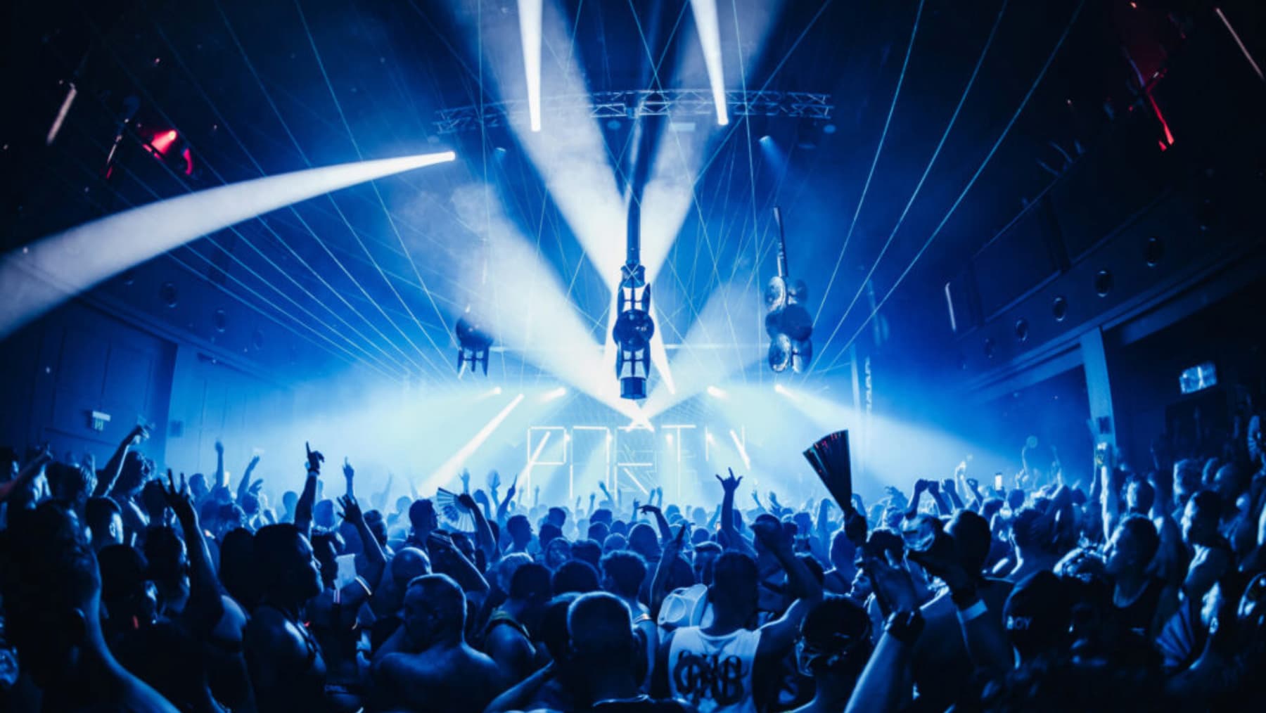 Club Gras takes over the ivy for a mid-week Sydney Mardi Gras party. Revellers are pictured in a dark club with blue lights and lasers.