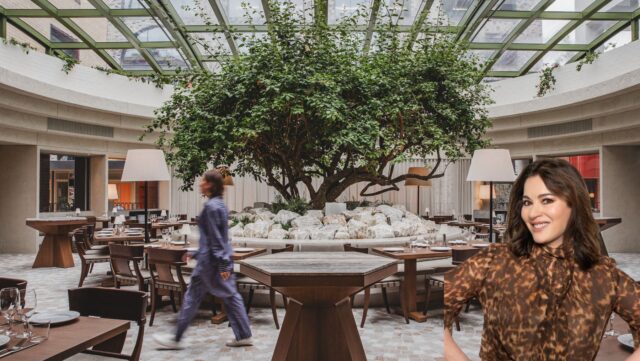 a group of people walking in a room with tables and chairs