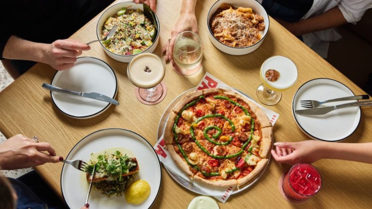 a table with pizza and cocktails