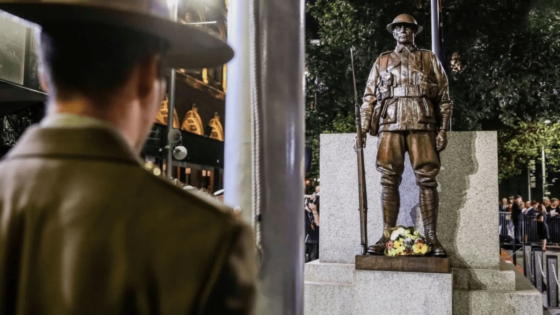 A soldier with his back to the camera in front of a statue at The Cenotaph