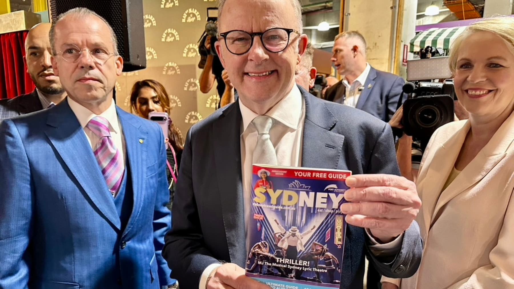 Anthony Albanese holding the Sydney Travel Guide