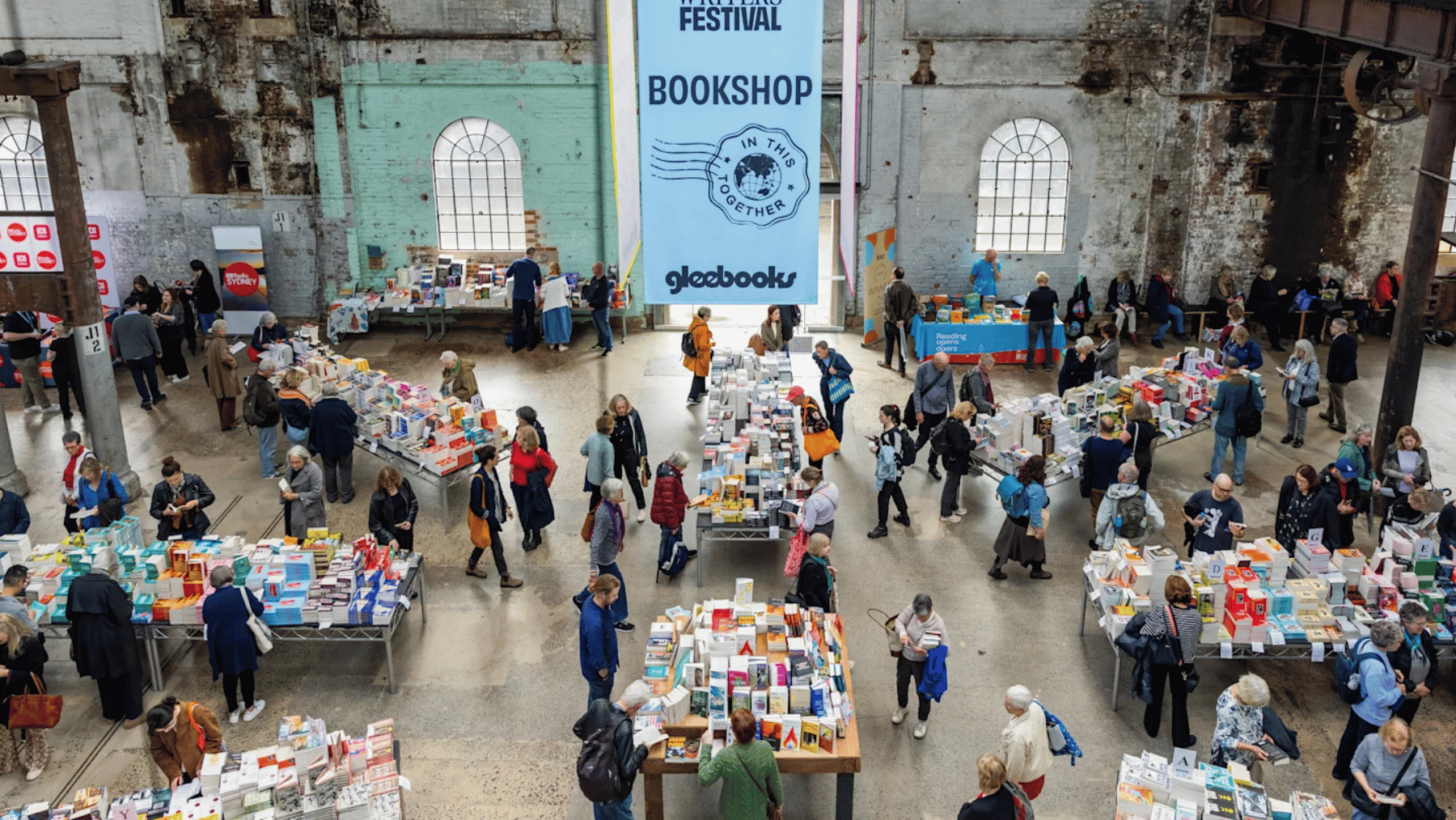 An overhead shot of people shopping for books at several tables