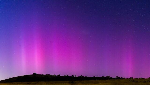 a purple and purple sky with stars