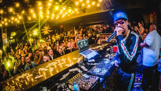 Snoop Dogg DJing at a nightclub.