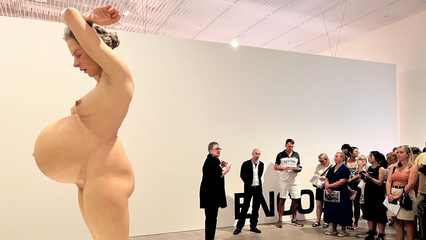 visitors look at Encounter by Ron Mueck's Pregnant Woman (2002)