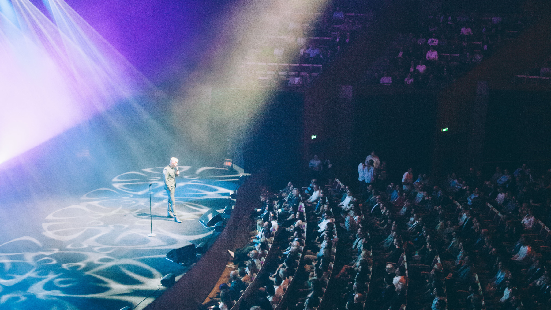 a packed theatre watching a comedian