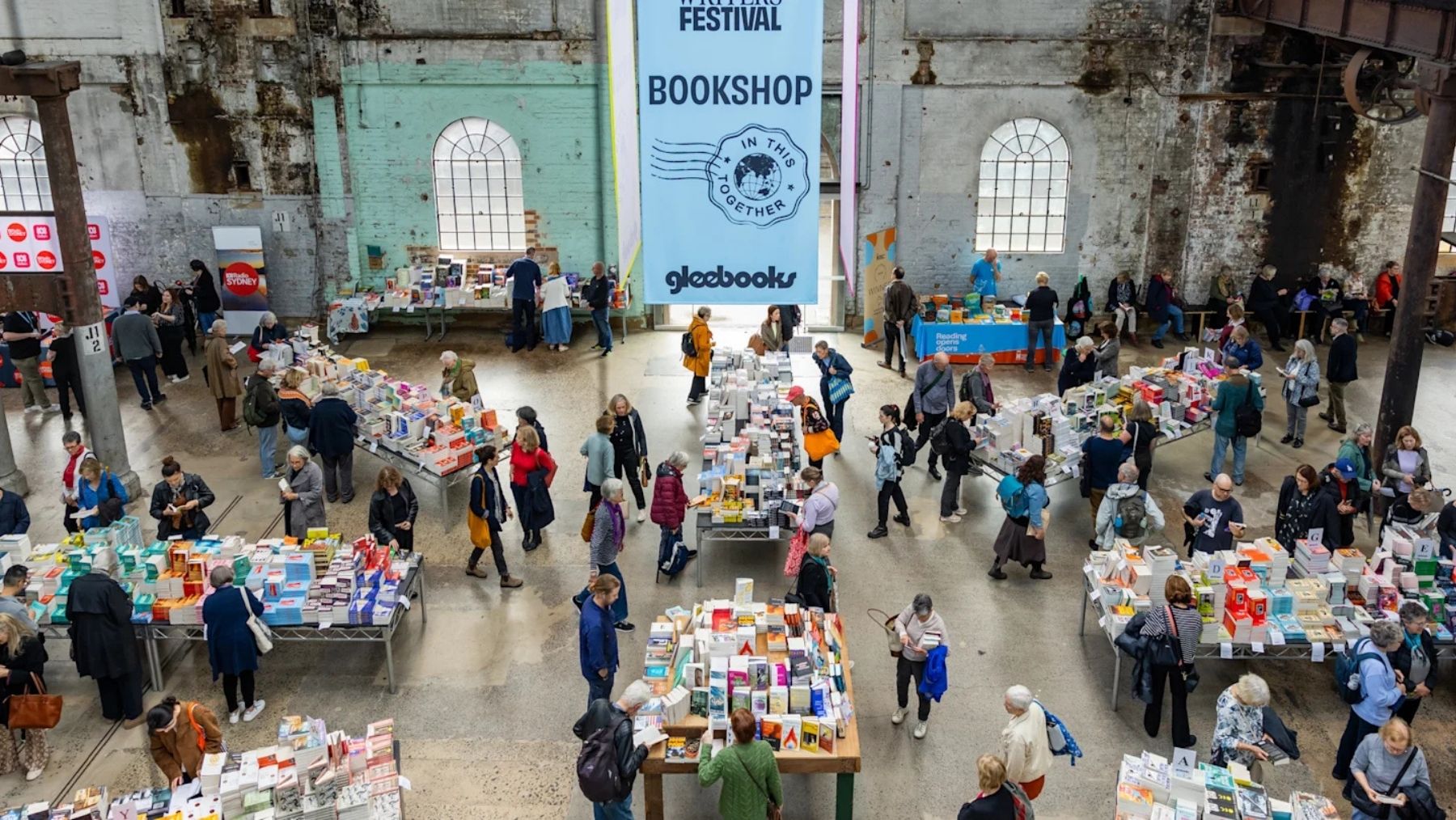An overhead shot of people shopping for books at several tables