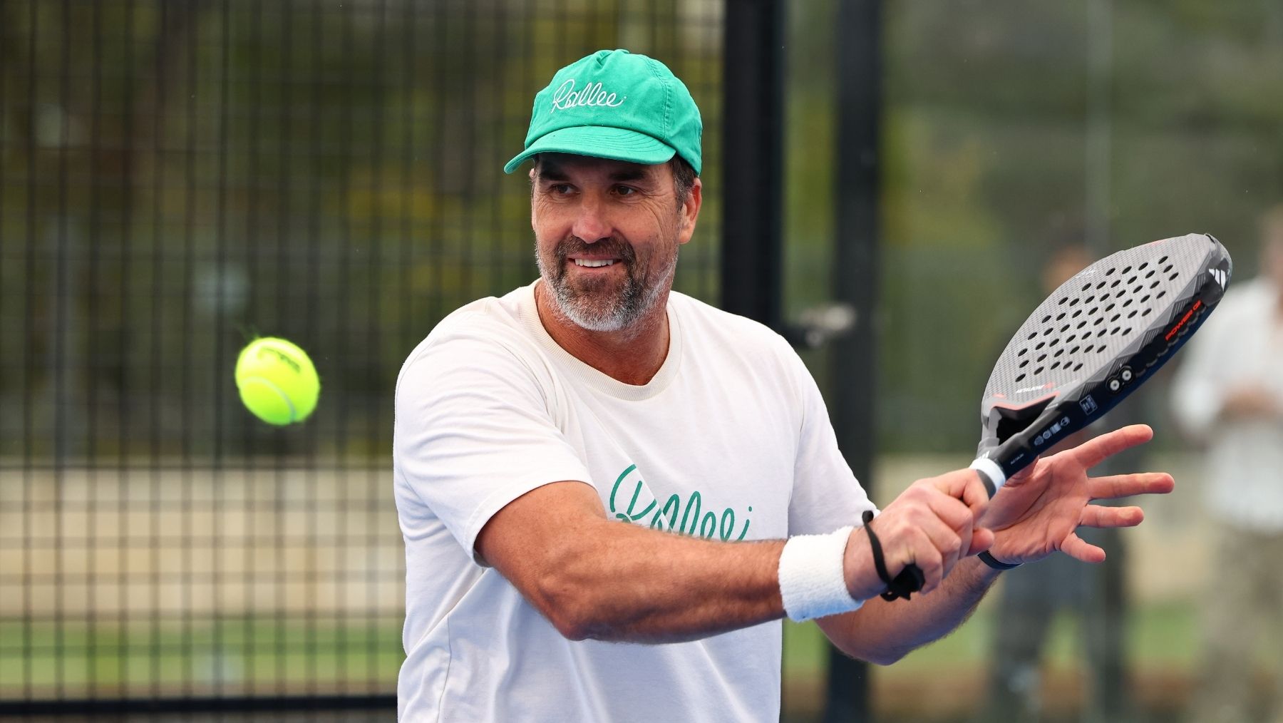 A man dressed in sports clothing plays padel
