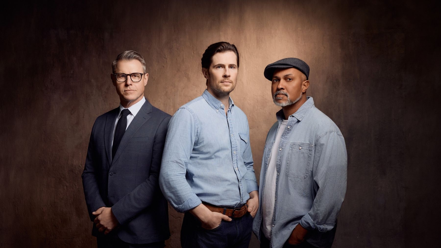 Three men in suits and casual attire